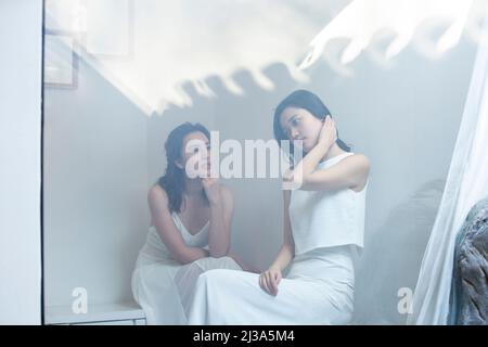 Kreative Bilder von modischen weiblichen Models mit wunderschönen Kleidern und zarten Make-up stehen im Fenster von Luxusgütern - Stock Foto Stockfoto