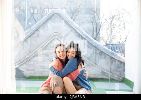 Wiedervereint nach einer langen Trennung, die Freizeit der schönen jungen modischen chinesischen Damen - Stock Foto Stockfoto