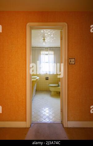 Ein Retro-Badezimmer aus den Jahren 1960s oder 1970s mit gelbem Thema. Dieses Haus wurde seitdem abgerissen. Stockfoto