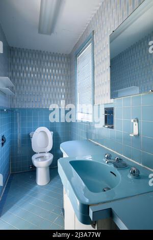 Ein Retro-Badezimmer aus den Jahren 1960s oder 1970s mit einem blauen Thema. Dieses Haus wurde seitdem abgerissen. Stockfoto