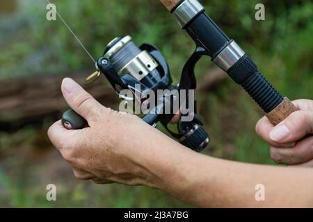 Nahaufnahme der Hand einer Frau auf einer Angelrute. Stockfoto