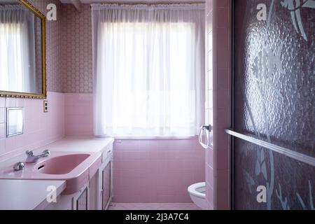 Ein Retro-Badezimmer aus den Jahren 1960s oder 1970s mit einem rosa Thema. Dieses Haus wurde seitdem abgerissen. Stockfoto