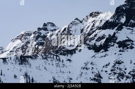 Zerklüftete schneebedeckte Gipfel in der Absaroka Range nahe dem nordöstlichen Eingang zum Yellowstone National Park. Stockfoto