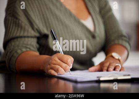 Tödlich mit einem Stift. Nicht erkennbare Aufnahme einer Frau, die zu Hause Schreibarbeiten macht. Stockfoto