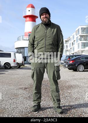 05. April 2022, Mecklenburg-Vorpommern, Warnemünde: Monchi (Jan Gorkow), Sänger der Punkband feine Sahne Fischfilet, vor dem DOCK INN Hostel. Der 34-Jährige hat ein Buch mit dem Titel 'Niemals satt' ('über den Hunger nach Leben und 182 Kilo auf der Skala') geschrieben, das am 7. April 2022 bei Kiepenheuer & Witsch veröffentlicht wird. Gleichzeitig startet er eine Lesetour über 17 Stationen. Foto: Bernd Wüstneck/dpa Stockfoto