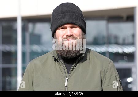 05. April 2022, Mecklenburg-Vorpommern, Warnemünde: Monchi (Jan Gorkow), Sänger der Punkband feine Sahne Fischfilet, vor dem DOCK INN Hostel. Der 34-Jährige hat ein Buch mit dem Titel 'Niemals satt' ('über den Hunger nach Leben und 182 Kilo auf der Skala') geschrieben, das am 7. April 2022 bei Kiepenheuer & Witsch veröffentlicht wird. Gleichzeitig startet er eine Lesetour über 17 Stationen. Foto: Bernd Wüstneck/dpa Stockfoto