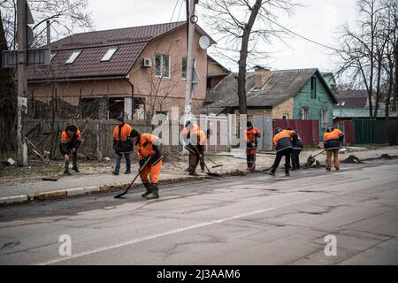 Irpin, Ukraine. 06. April 2022. Arbeiter, die in Irpin, einer Stadt in der Nähe von Kiew, die vor kurzem von russischen Truppen befreit wurde, die Straße säubern. Russland marschierte am 24. Februar 2022 in die Ukraine ein und löste damit den größten militärischen Angriff in Europa seit dem Zweiten Weltkrieg aus Kredit: SOPA Images Limited/Alamy Live Nachrichten Stockfoto