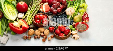 Köstliches rohes Obst und Gemüse auf hellem Hintergrund. Gesundes Lebensmittelkonzept. Panorama, Kopierraum Stockfoto