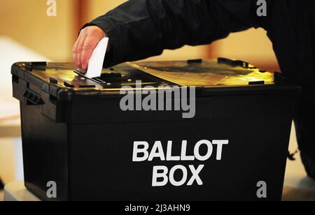 Aktenfoto vom 06/05/10 eines Wählers, der einen Stimmzettel in die Wahlurne legt. Menschen, die im nächsten Monat in ganz Großbritannien Wahlen abhalten wollen, haben nur noch wenige Tage Zeit, sich für ihre Stimme anzumelden. Ausgabedatum: Donnerstag, 7. April 2022. Stockfoto