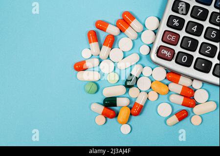 Medizinisches Konzept mit verschiedenen Medikamenten und Rechner auf blauem Hintergrund Stockfoto