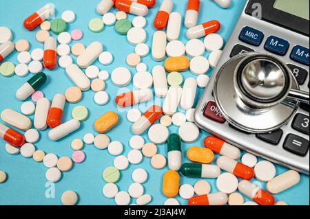 Medizinisches Konzept mit verschiedenen Medikamenten und Rechner auf blauem Hintergrund Stockfoto