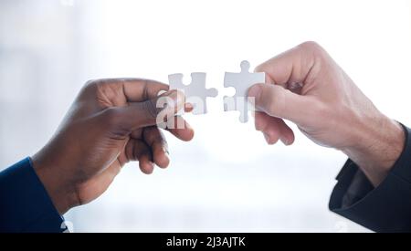 Probleme werden gemeinsam besser gelöst. Eine kurze Aufnahme von zwei nicht erkennbaren Geschäftsleuten, die in einem modernen Büro gemeinsam ein Rätsel lösen. Stockfoto