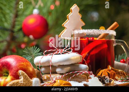 Weihnachtsfeier-Konzept mit Tasse Grog, Weihnachtsplätzchen, Obst und Gewürzen, Nahaufnahme mit selektivem Fokus auf den Hintergrund der Weihnachts-t Stockfoto