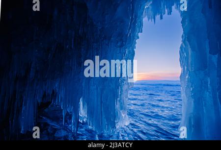 Blaue Eishöhle oder Grotte am Wintersee Baikal. Schöne Winterlandschaft mit langen Eiszapfen. Stockfoto