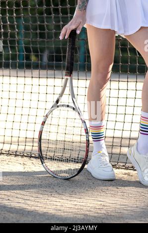 Nicht erkennbare Frau mit Tennisschläger. Nahaufnahme einer Frau in Sportkleidung mit Tennisschläger Stockfoto