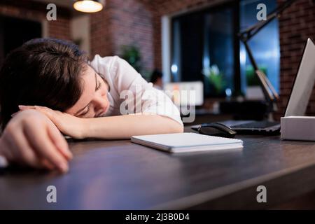 Erschöpfter Manager, der nach Überstunden an Müdigkeit leidet. Müde Büroangestellte mit Burnout-Syndrom schlafen bei der Arbeit wegen extremer Müdigkeit. Stockfoto