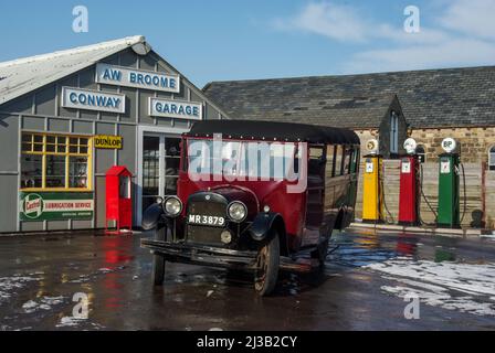 Altmodische Garage und Benzinpumpen mit Oldtimer auf dem Vorplatz, Black Country Living Museum, Dudley, Großbritannien Stockfoto