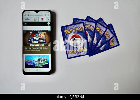 Prag, Tschechische Republik - April 3 2022: Rückseite von Pokemon-Karten und Smartphone-Smartphone mit offener Online-Version von Pokemon Trading Card Game. Stockfoto