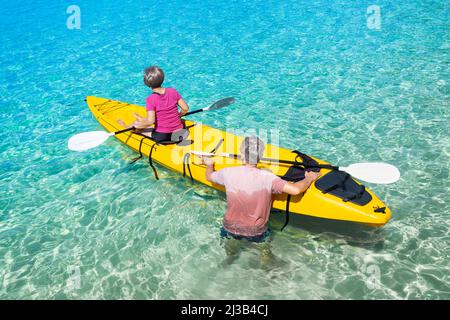 Asiatisches Seniorenpaar im Kajak auf Abenteuerreise in Südostasien. Stockfoto