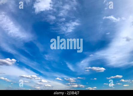 Fedrige und flauschige Wolken auf einem fedrigen und flauschigen Wolken auf einem Hintergrund des blauen Himmels. Hintergrund des blauen Himmels. Stockfoto