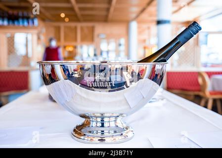 Champagnerflasche in silbernem Eiskübel aus Metall auf dem Tisch im Restaurant Stockfoto