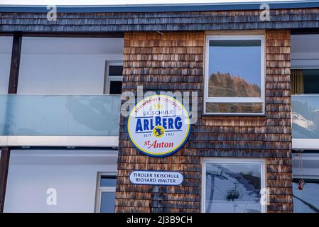 Logo-Beschilderung des Unternehmens neben Glasfenstern an der Wand des Gebäudes Stockfoto