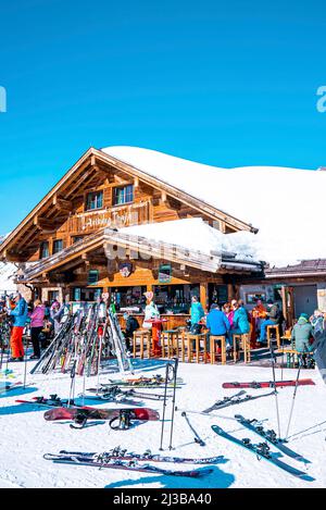 Menschen, die während des Skiurlaubs an sonnigen Tagen im Bergcafé sitzen Stockfoto