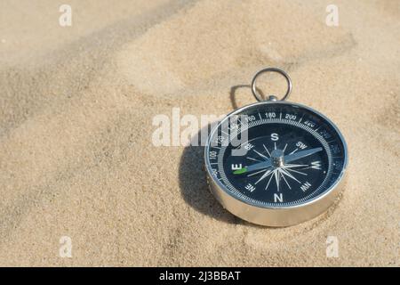 Kompass im Sand am Strand vergraben Konzept von verloren oder Richtung Stockfoto