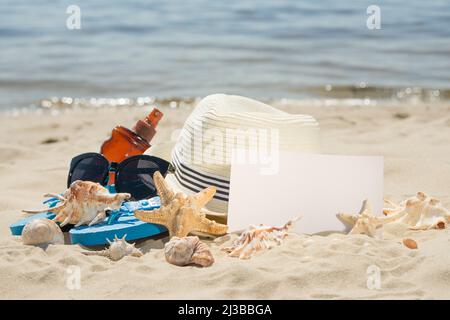 Hut am Strand, Sonnenbrille, Muscheln und ein Stern. Auf weißem Sand, mit einer leeren Stelle für die Inschrift Stockfoto