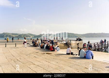 Tourist Entspannung auf Steinmauern am Ufer des Flusses Tejo in belém, Lissabon, Portugal Stockfoto