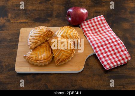 apfelumdrehungen auf Holzhintergrund Stockfoto