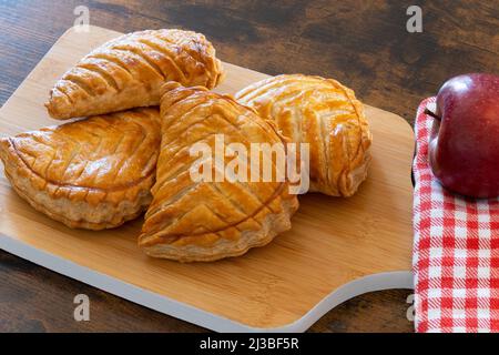 apfelumdrehungen auf Holzhintergrund Stockfoto