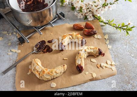 Backen von gesunden Mandelblättchen aus Mandeln, Haferflocken und Datteln mit dunkler Schokolade, rustikalem grauen Hintergrund, Kopierraum, ausgewählter Fokus, nar Stockfoto