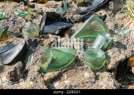 Eingebettetes gebrochenes Glas, Wandplatte, Sicherheitsmaßnahme, illegal, gefährlich, Nicht ermutigt, altmodisch, Glasflaschen, eingefügter nasser Beton, scharf, Alt Stockfoto