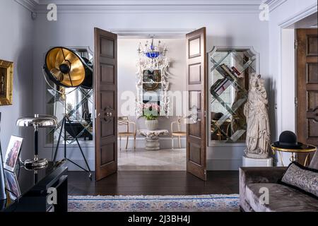 Vintage Stativlampe und Statue mit Blick auf Chinoiserie Spiegel und Regency Sessel in Holland Park Haus, London, UK Stockfoto