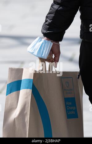 Dresden, Deutschland. 07. April 2022. Ein Mann trägt auf der Prager Straße eine OP-Maske am Handgelenk. In Sachsen wurde nach etwa zwei Jahren die Pflicht zum Tragen von Masken in den Geschäften eingestellt. Quelle: Sebastian Kahnert/dpa/Alamy Live News Stockfoto