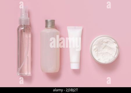 Hausgemachte Kosmetik in Plastikröhrchen und Flaschen auf rosa Draufsicht. Modell der Markenverpackung. Bio-Naturkosmetik für die Haut- und Haarpflege Stockfoto