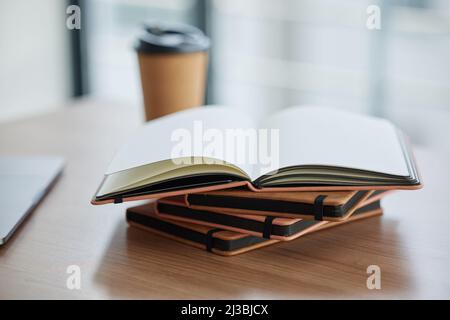 Ziele sollten schriftlich festgehalten werden. Aufnahme eines Bücherstapels an einem Tisch in einem modernen Büro. Stockfoto