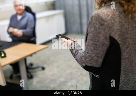 Frau mit Smartphone im Büro Stockfoto