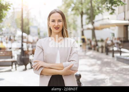 Attraktive junge Frau, die auf einer Stadtstraße steht. Stockfoto