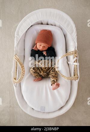 Neugeborener Junge, der im Kinderbett schläft Stockfoto