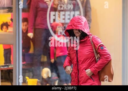 Preston, Lancashire. Wetter in Großbritannien 07. April 2022. Starke Winde und heftige Regengüsse in Preston, wenn die Temperaturen auf 7c sinken. Die Einkäufer werden nass, wenn es regnet und die Windböen die Stimmung auf der Straße dämpfen. Sehr windig mit April-Schauern den ganzen Tag über. Quelle: MediaWorldImages/AlamyLiveNews Stockfoto