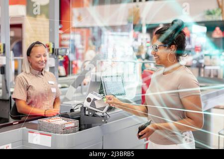 Frau, die im Geschäft mit Karte bezahlt Stockfoto