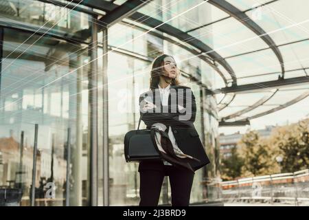 Junge Geschäftsfrau, die vor dem Büro steht Stockfoto