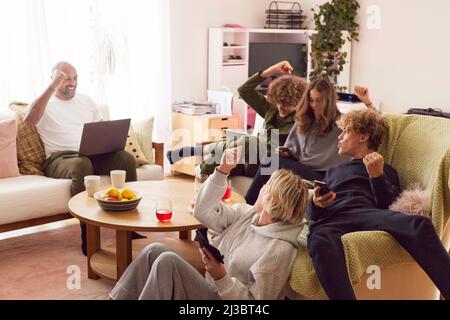 Familie mit Kindern mit elektronischen Geräten und Jubel Stockfoto