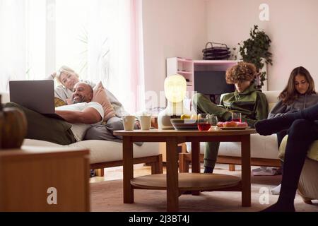 Familie mit Kindern, die sich im Wohnzimmer entspannen Stockfoto