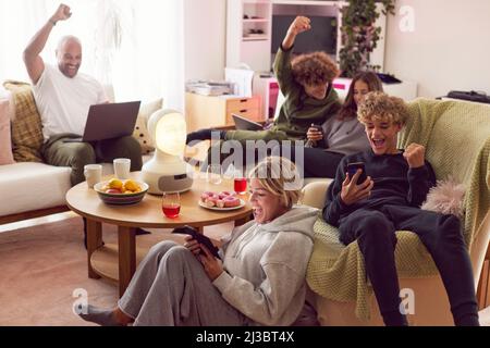 Familie mit Kindern mit elektronischen Geräten und Jubel Stockfoto