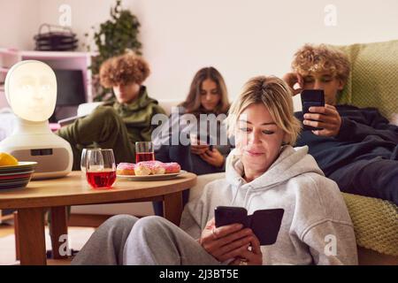 Mutter mit Kindern, die zu Hause elektronische Geräte benutzen Stockfoto