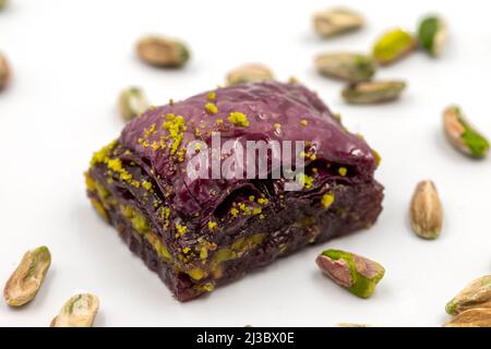 Pistazien lila Baklava auf weißem Hintergrund. Baklava speziell für Diabetiker vorbereitet. Traditionelle Köstlichkeiten der mediterranen Küche. Nahaufnahme Stockfoto