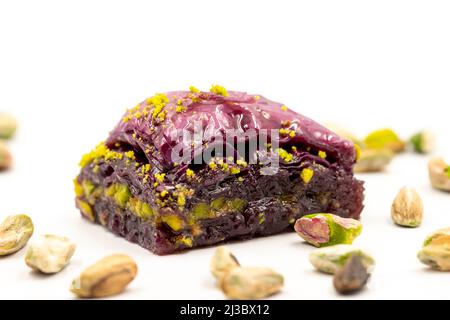 Pistazien lila Baklava auf weißem Hintergrund. Baklava speziell für Diabetiker vorbereitet. Traditionelle Köstlichkeiten der mediterranen Küche. Nahaufnahme Stockfoto